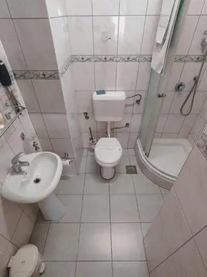 a bathroom with a toilet and a sink and a shower at Motel West in Zenica