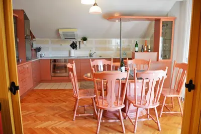 a kitchen with a table and chairs in a room at Apartman EXCLUZIV in Prijedor