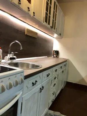 a kitchen with white cabinets and a sink at Apartman EXCLUZIV in Prijedor