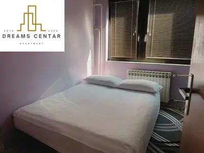 a bed with two pillows on it in a room at Apartments Dreams Centar in Živinice