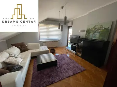 a living room with a white couch and a table at Apartments Dreams Centar in Živinice