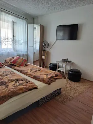 a bedroom with a bed and a television on the wall at Apartmani Konta in Livno