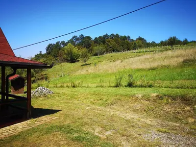 a view of a field with a house and a hill at Katarina Doboj,Bušletić in Busletić