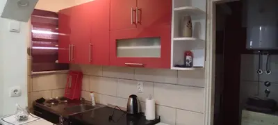 a kitchen with red cabinets and a sink at Lara in Doboj