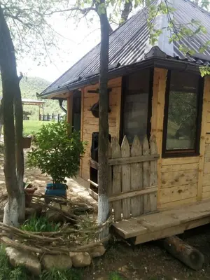 a wooden cabin with a fence in a yard at Bungalows Old Town in Visoko