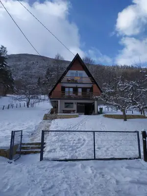 a house with a fence in the snow at Apartment Stanic in Šipovo
