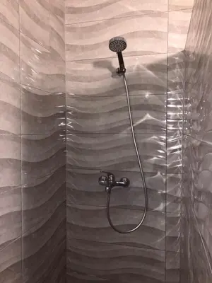 a shower with a shower head on a glass wall at Villa Happy dreams in Bihać