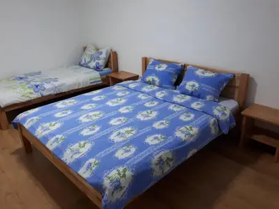 a bedroom with a bed with a blue comforter at Apartmani Tajra in Visoko