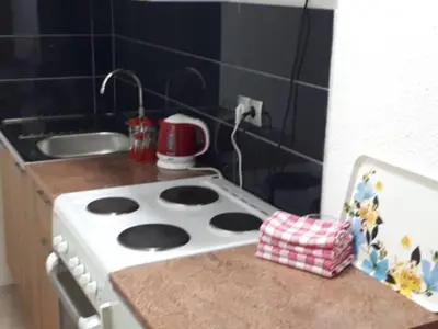 a kitchen counter with a stove and a sink at Apartmani Tajra in Visoko