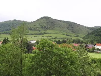a mountain in the distance with trees and houses at Apartmani Tajra in Visoko