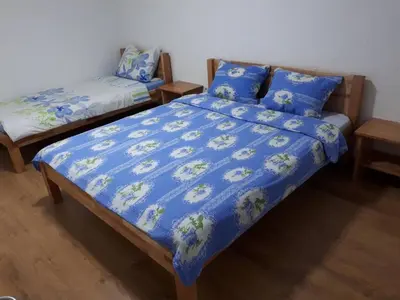 a bedroom with two beds with blue comforter at Apartmani Tajra in Visoko