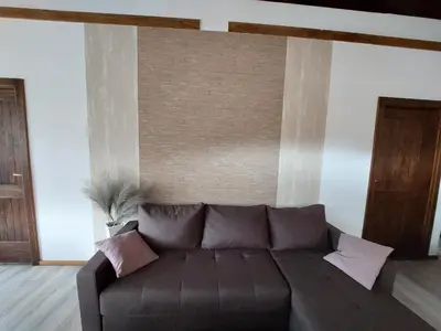 a brown couch in a living room with a wall at ATRIUM Holiday home in Bihać