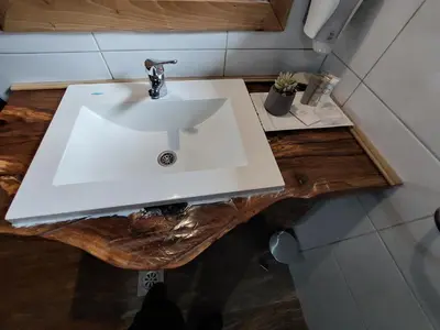 a white sink on a wooden counter in a bathroom at ATRIUM Holiday home in Bihać