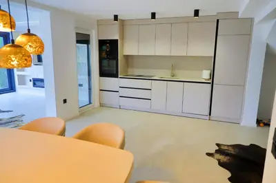 a kitchen with white cabinets and a table and chairs at Casa Dellˇ Amore in Bihać