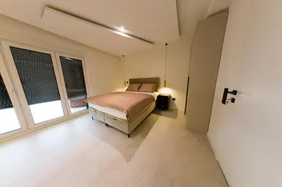 a bedroom with a bed and two windows at Casa Dellˇ Amore in Bihać