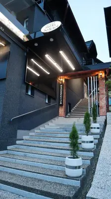 a building with stairs and potted plants in front of it at So&sol boutique Hotel, Tuzla in Tuzla