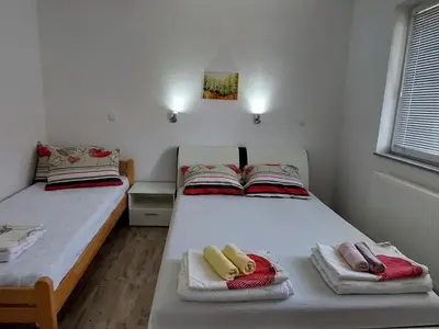 a bedroom with two beds with towels on them at Apartments Window in Bihać
