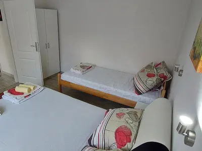 a small room with two beds and a chair at Apartments Window in Bihać