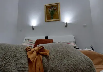 a bedroom with two beds and a picture on the wall at Apartments Window in Bihać