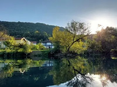 a view of a river with trees and houses at Apartments Window in Bihać