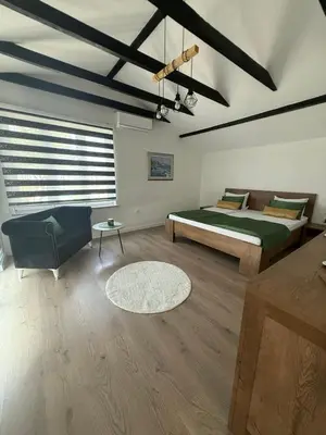 a bedroom with a bed and a couch and a table at Family estate Hadžalova avlija in Bihać