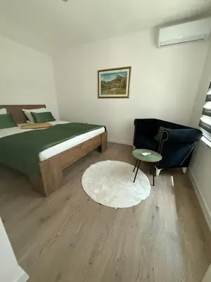 a bedroom with a bed and a chair and a rug at Family estate Hadžalova avlija in Bihać