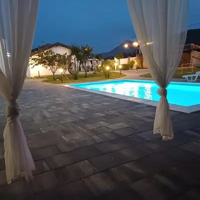 a room with a view of a swimming pool at night at Family estate Hadžalova avlija in Bihać