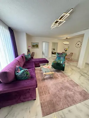 a living room with a purple couch and chairs at Family estate Hadžalova avlija in Bihać