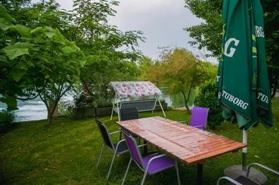 a table and chairs with a table and a umbrella at LGP Exclusive Apartment in Bihać
