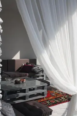 a living room with white curtains and a coffee table at LGP Exclusive Apartment in Bihać