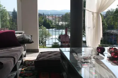 a living room with a couch and a glass table at LGP Exclusive Apartment in Bihać