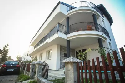 a white house with a fence in front of it at LGP Exclusive Apartment in Bihać