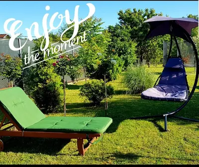 a green chair and an umbrella and a swing at Una Valley Bihać in Bihać