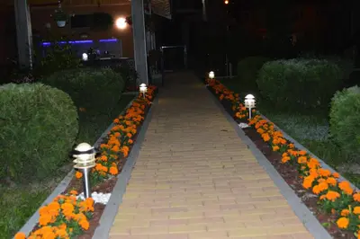a brick walkway with flowers in a garden at night at Una Valley Bihać in Bihać