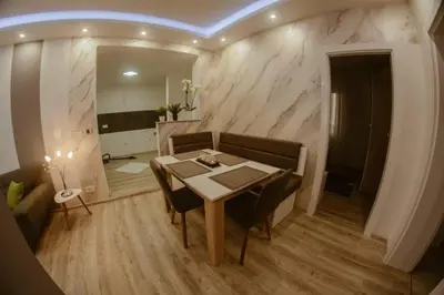 a dining room with a table and a couch at Una Valley Bihać in Bihać