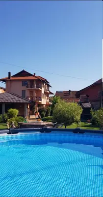 a large blue swimming pool in front of a building at Una Valley Bihać in Bihać