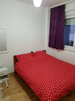 a red bed with polka dot sheets in a bedroom at Modern apartment in Banja Luka
