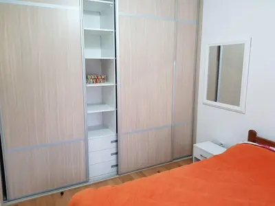 a bedroom with an orange bed and a closet at Modern apartment in Banja Luka