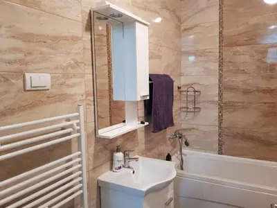 a bathroom with a sink and a mirror and a tub at Modern apartment in Banja Luka