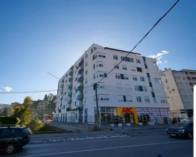 a white building with cars parked in front of it at Modern apartment in Banja Luka