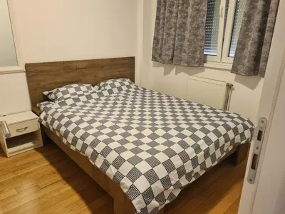 a small bedroom with a bed with a checkered blanket at Modern apartment in Banja Luka