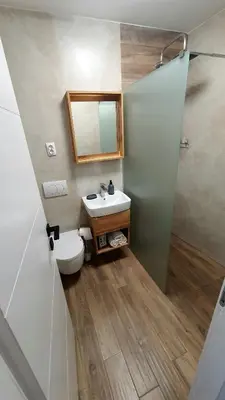 a bathroom with a toilet and a sink and a mirror at Apartman Campari in Banja Luka