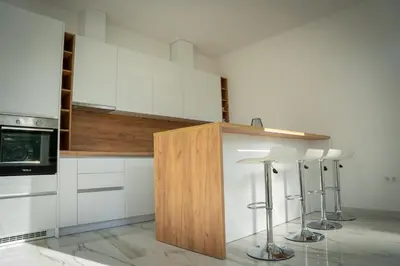 a kitchen with white cabinets and bar stools at Apartment Una Laguna in Bihać