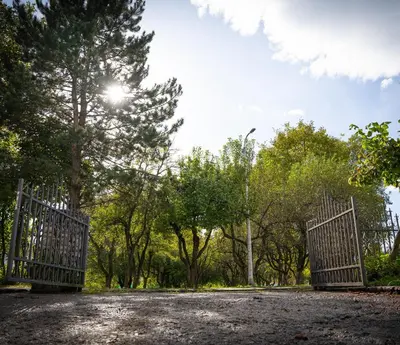a pair of gates in a park with trees at Apartment Una Laguna in Bihać