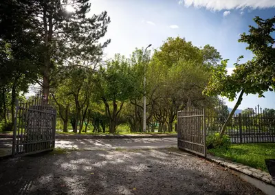 an open gate in a park with trees at Apartment Una Laguna in Bihać