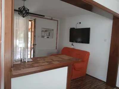 a room with a table and a chair and a television at Jovan in Šipovo