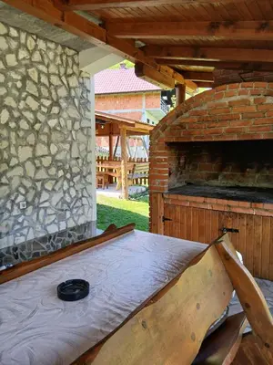 a bed in an outdoor room with a stone fireplace at Jovan in Šipovo