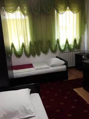 a bedroom with two beds and a window with curtains at 
