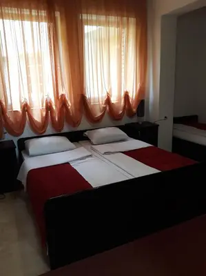 a bedroom with a large bed with an orange curtain at 