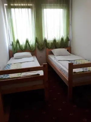 two beds in a room with green curtains at 